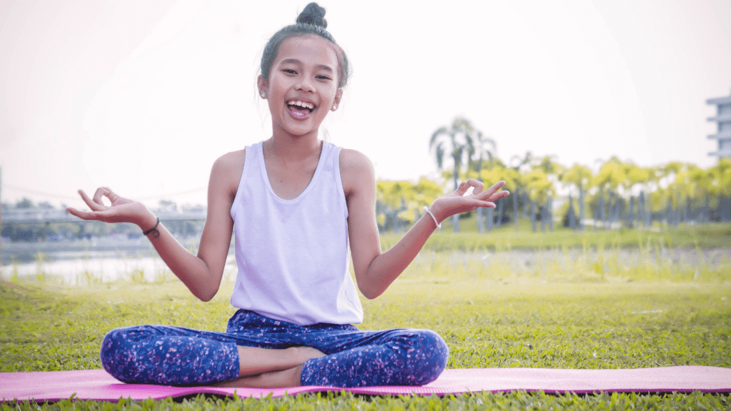 Student does a yoga pose outside on yoga mat.