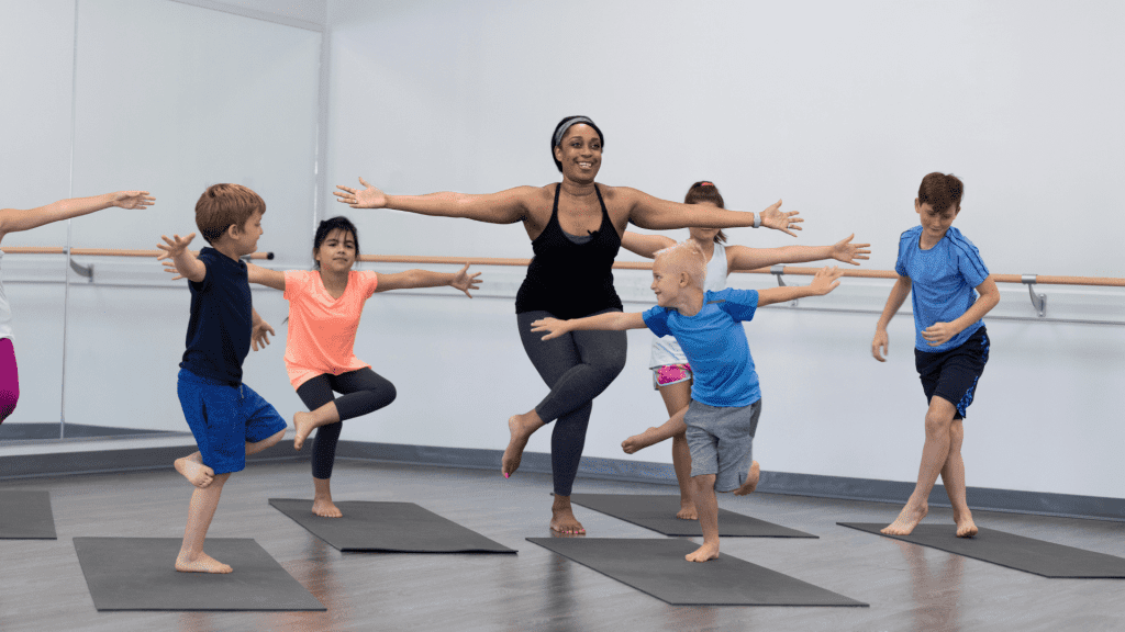 A yoga instructor teaches yoga to young students.