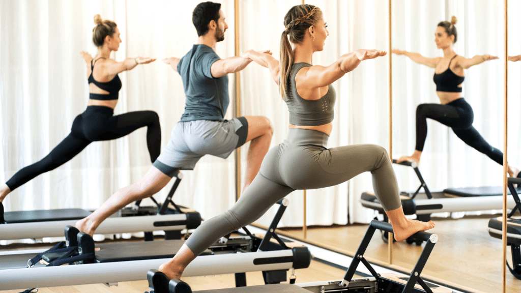 People workout on pilates reformers.