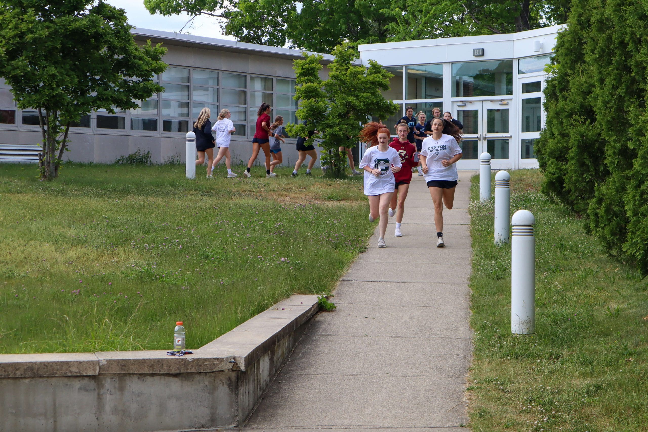 Students jog as part of a warm up for a high school workout.