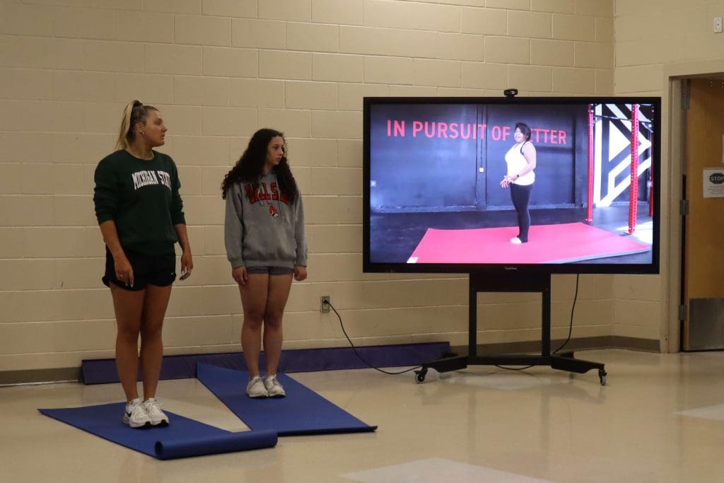 Students follow along to a PLT4M yoga lesson during physical education class.