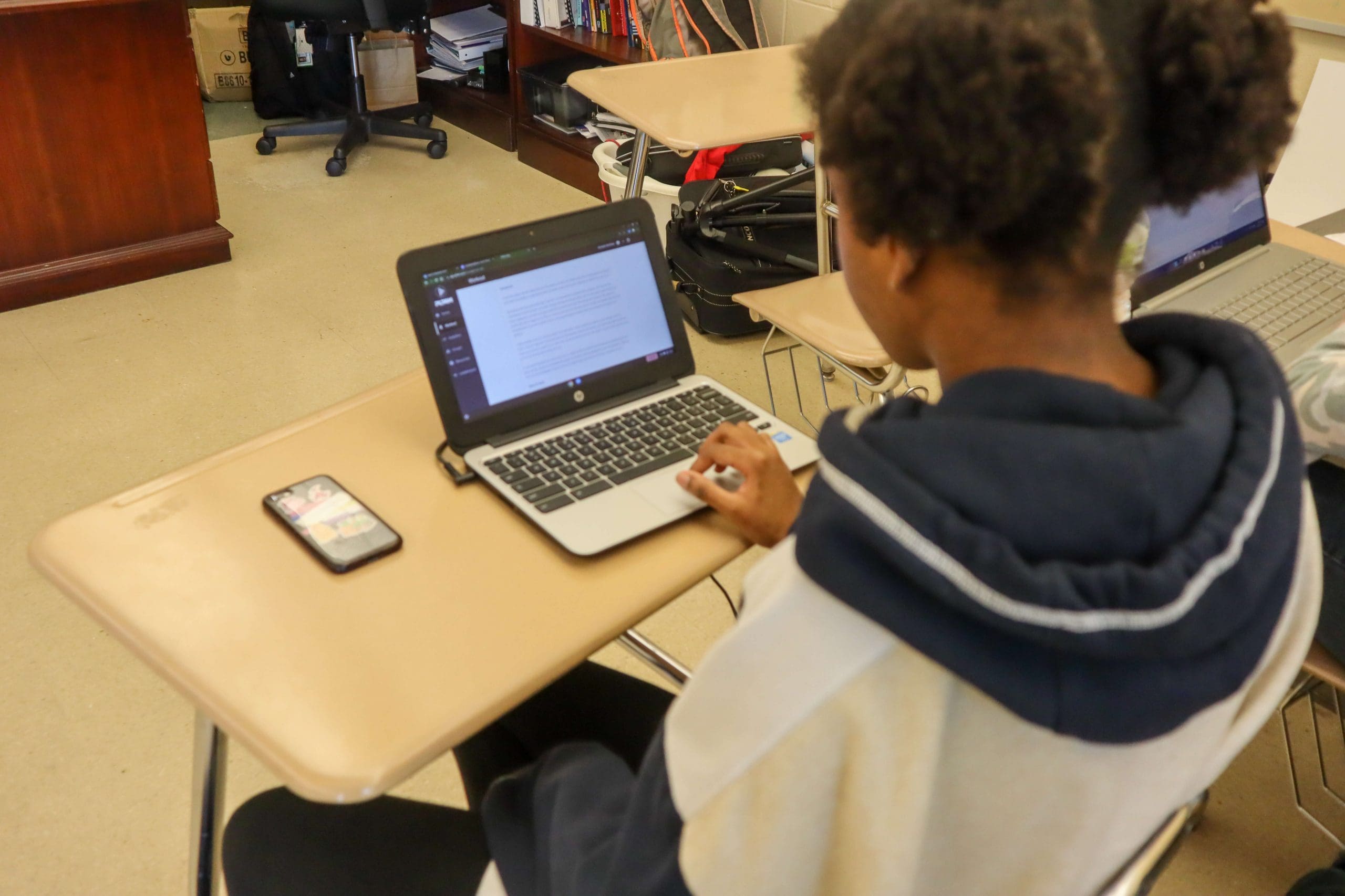 A student reads a PLT4M nutrition lesson a laptop.