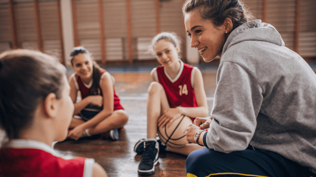A basketball coach talks with her athletes.