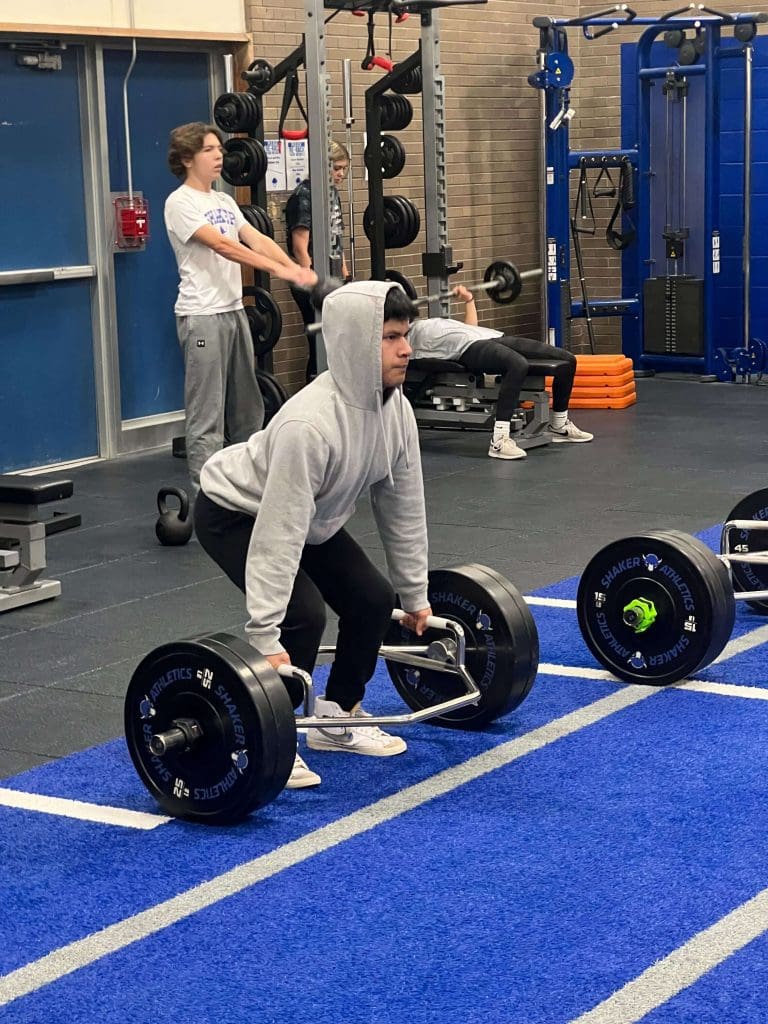 A student performs the trap bar deadlift.
