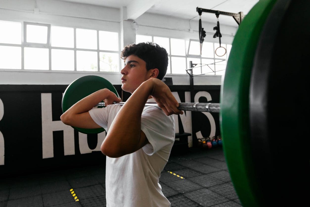 Student holding a barbell in front rack position.