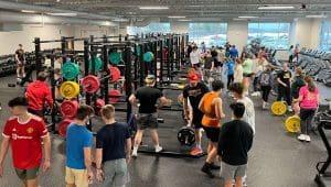 Bird's eye view of inside the Plymouth High School weight room with students training.