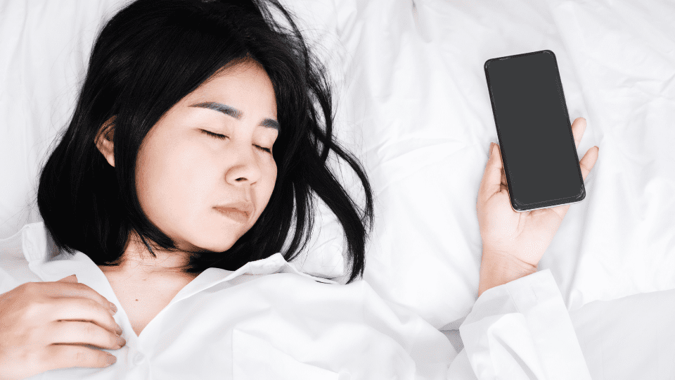 Teenager sleeps with phone in hand.