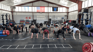 A group of students workout inside the Woodburn weight room.