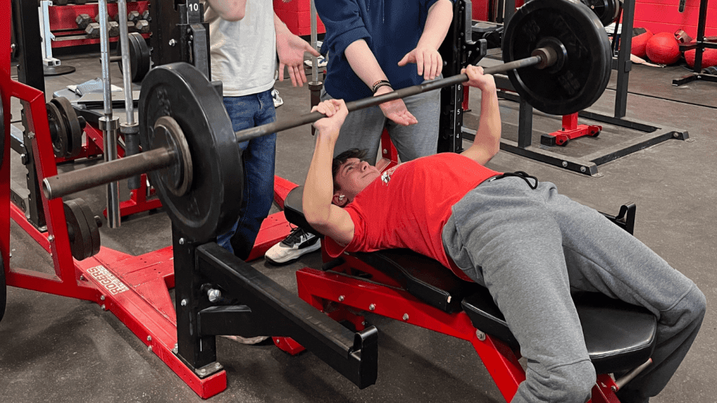 Student at St. Louis High School bench pressing.