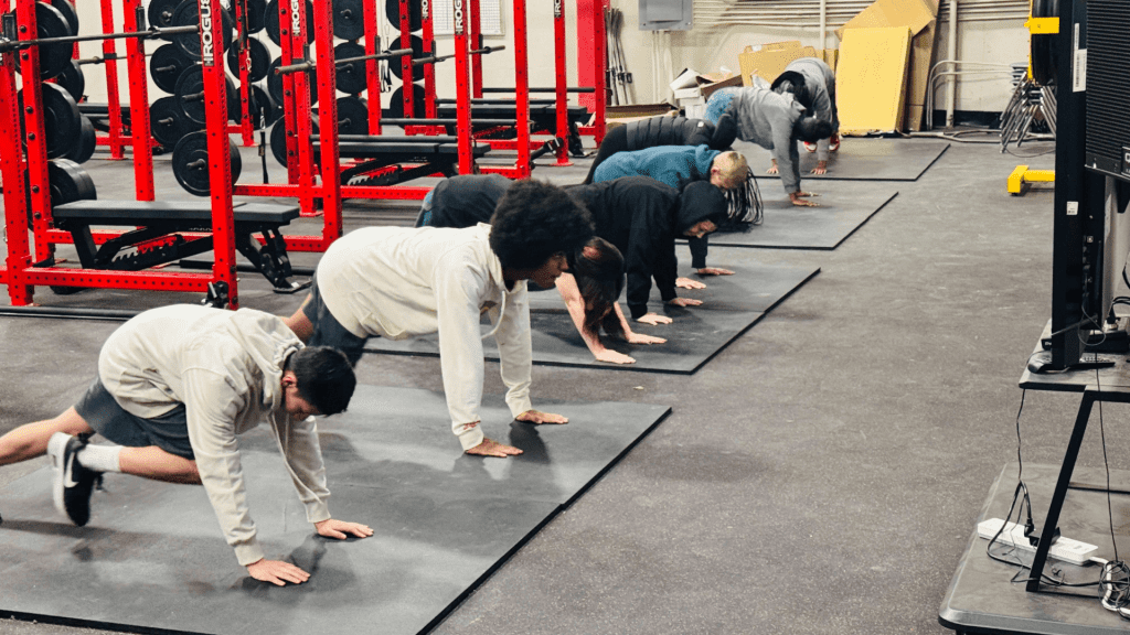 Students doing mountain climbers during PE class at North High School.